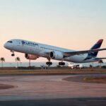 Aeronave Boeing 787 da Latam Airlines decolando durante o pôr do sol em aeroporto brasileiro com palmeiras ao fundo aviação comercial
